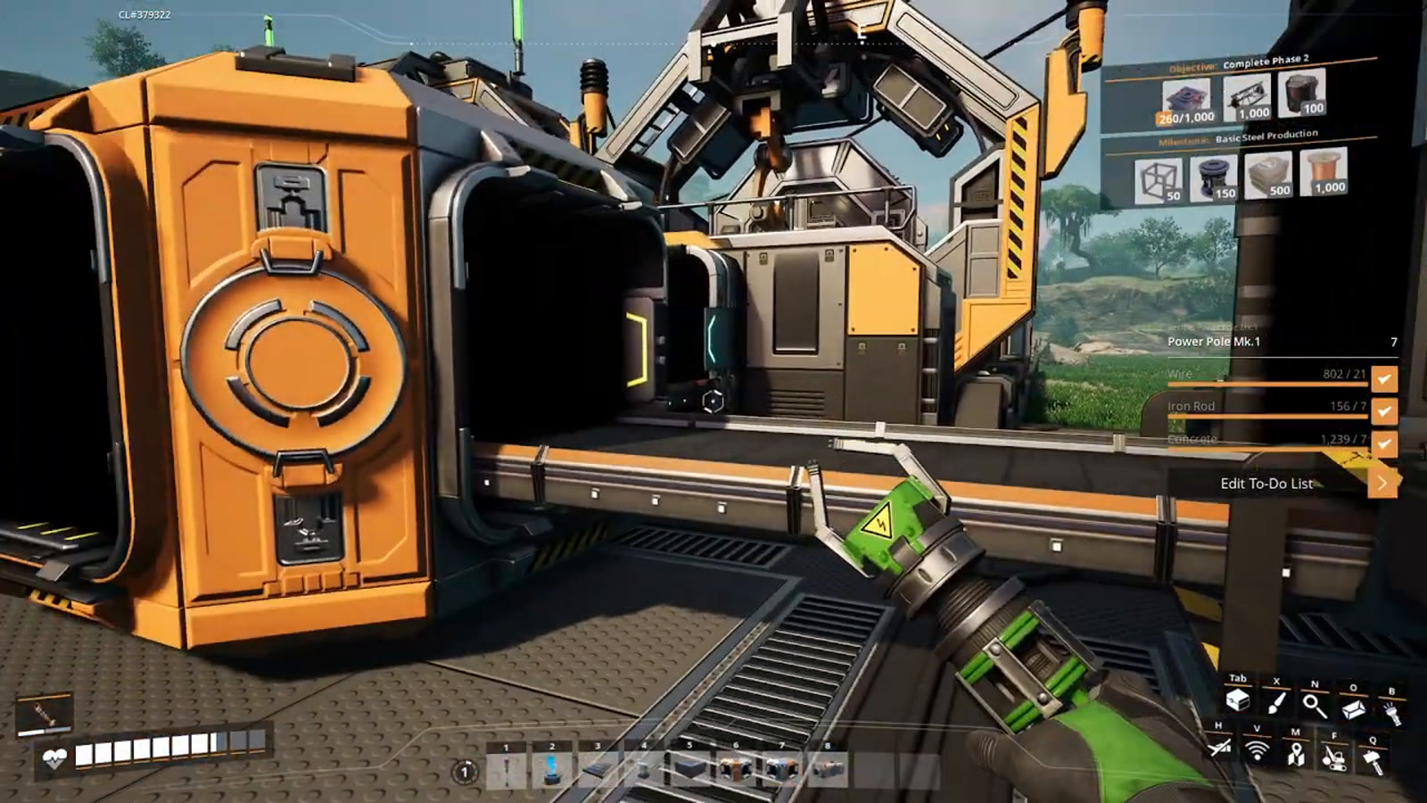 The completed Modular Frame factory built into the terrain, stockpiling output automatically while the rest of the base continues expanding elsewhere on the map