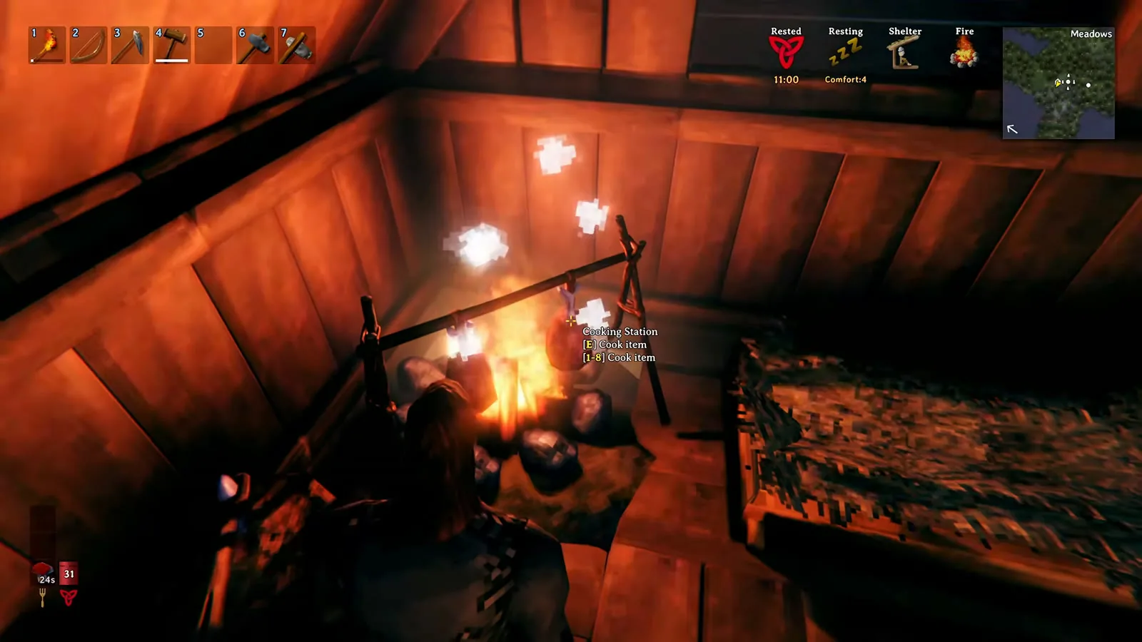 Cooking boar meat on a cooking station over the campfire inside a Valheim starter house